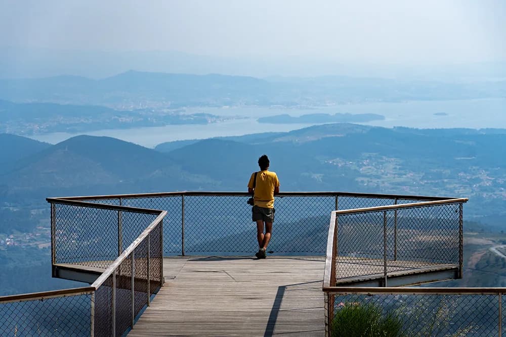 Paisaje verde de Galicia con bosques atlánticos y montañas bajo un cielo atlántico cambiante