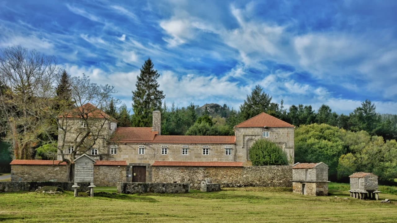 Pazo gallego de piedra rodeado de jardines y camelias utilizado como alojamiento rural con encanto